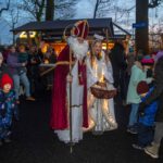 Engel und Nikolaus laufen über den Weihnachtsmarkt