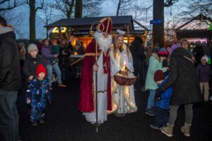 Engel und Nikolaus laufen über den Weihnachtsmarkt